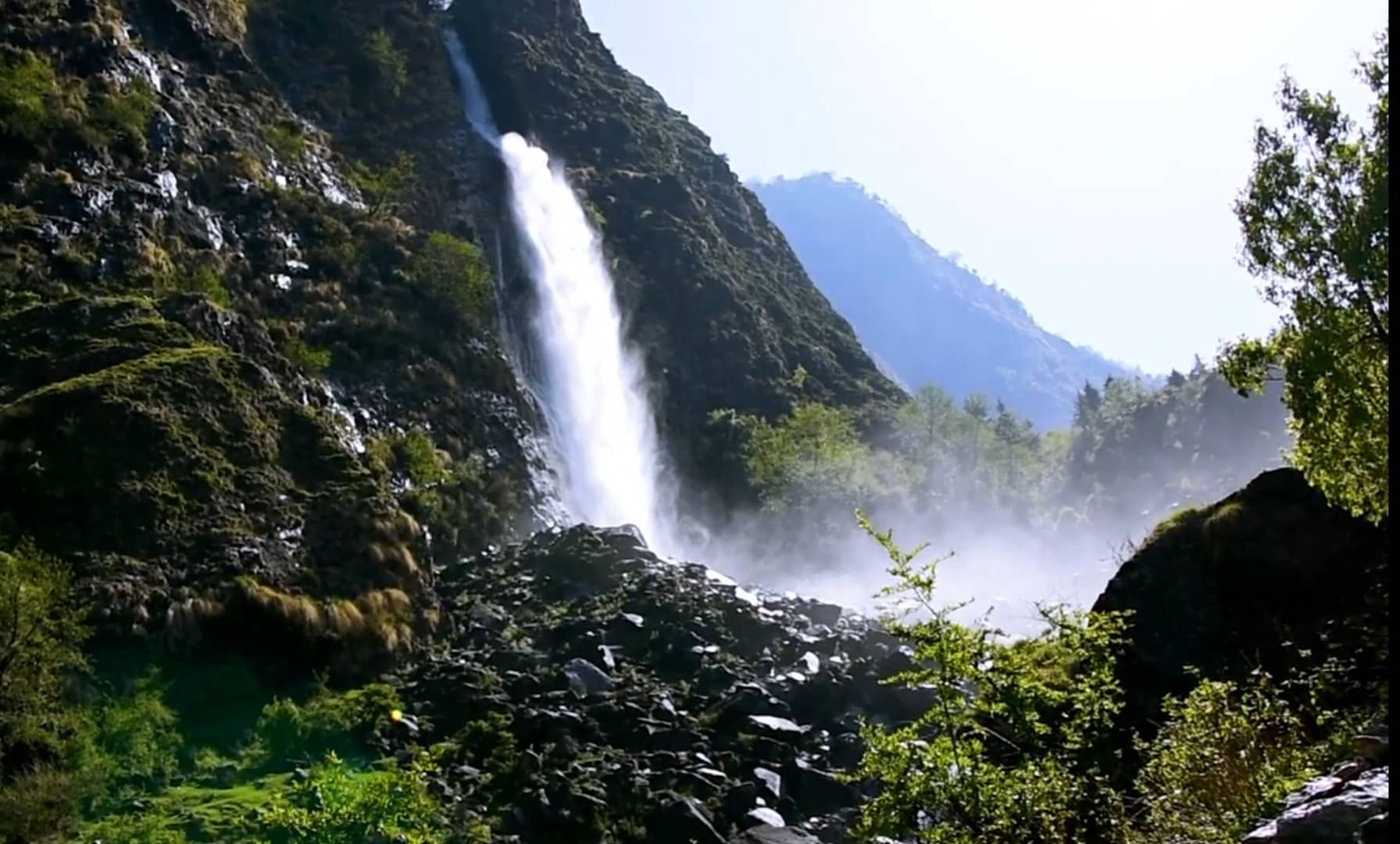 Birthi Waterfall dropping into mist and greenery