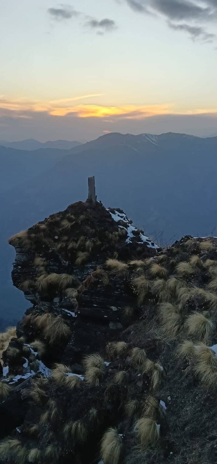 Sunset over layered ridges from a rocky summit