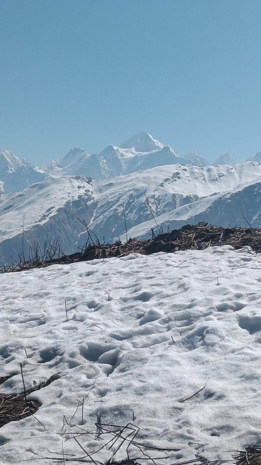 Snow-covered Himalayan peaks above a snowfield