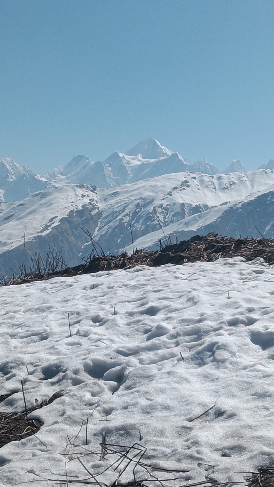 Snow-covered Himalayan peaks above a snowfield