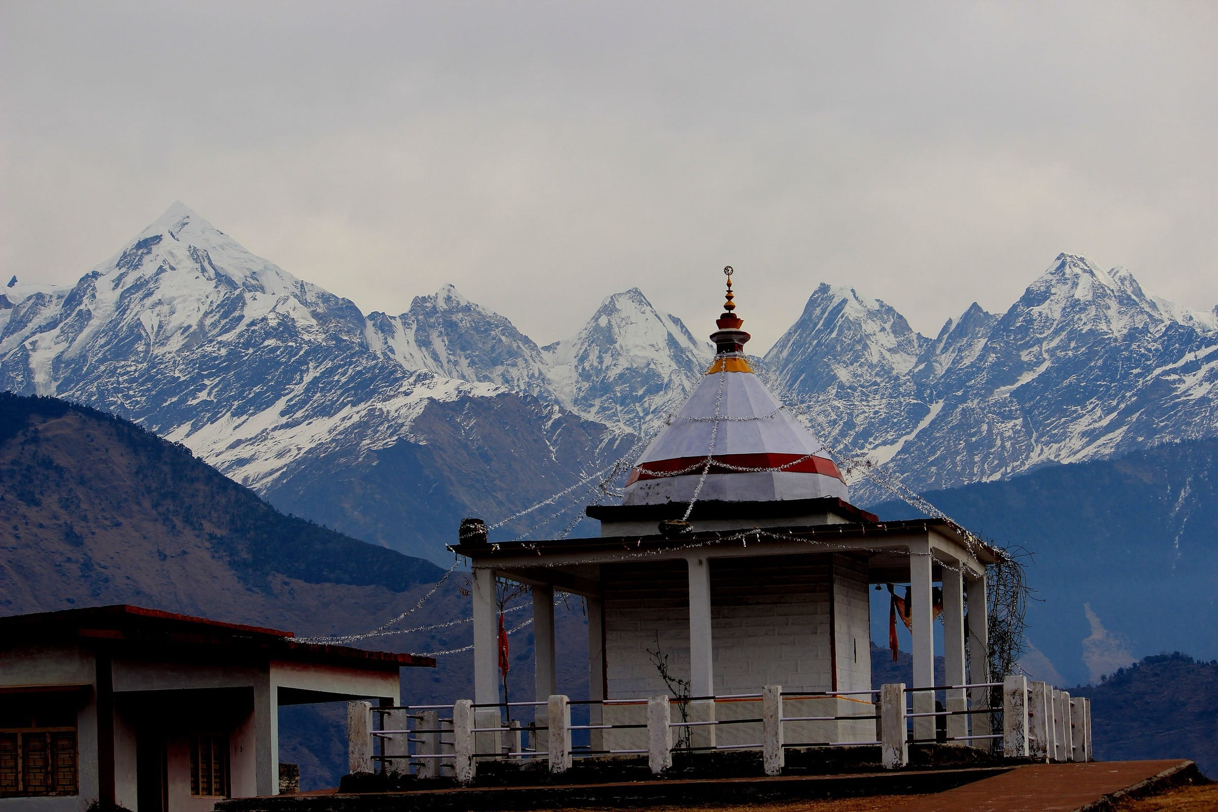 A hilltop temple in front of snowy peaks
